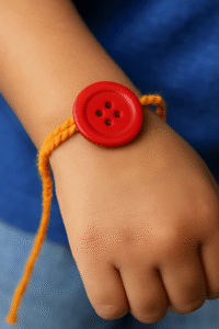 एक बच्चे की कलाई पर रंग-बिरंगे बटनों से बनी सुंदर राखी का क्लोज़अप दृश्य।