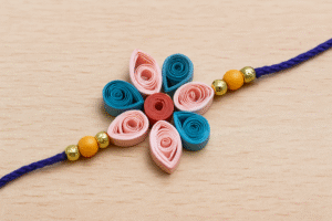 रंगीन क्विलिंग पेपर से बनी खूबसूरत राखी का क्लोज़अप दृश्य, बच्चों के लिए आसान DIY डिज़ाइन.