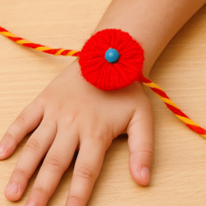 बच्चे के हाथ में पहनी गई रंगीन ऊन से बनी वूलन राखी का क्लोज़अप।